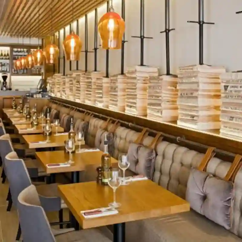 Accesorios para restaurante en Quintana Roo — espacio gastronómico completo con booth tapizado, mesas de madera, cristalería y luminarias decorativas para restaurantes premium en Cancún y Playa del Carmen