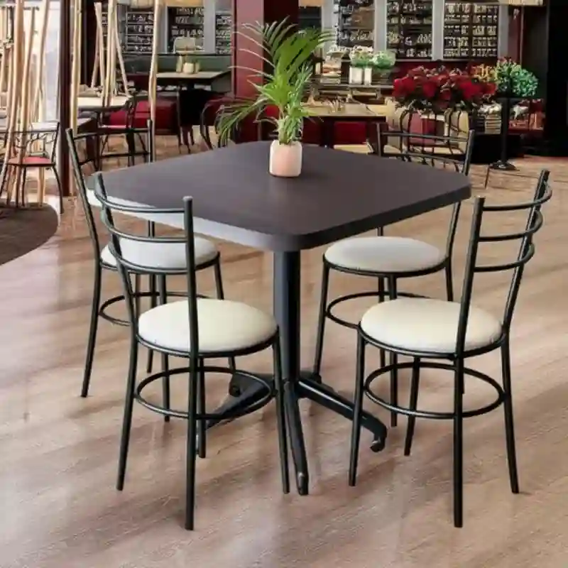 Sillas de acero para restaurante en Quintana Roo — conjunto de 4 sillas metálicas con asiento tapizado blanco y mesa cuadrada oscura, ideales para restaurantes en Cancún, Cozumel y Tulum