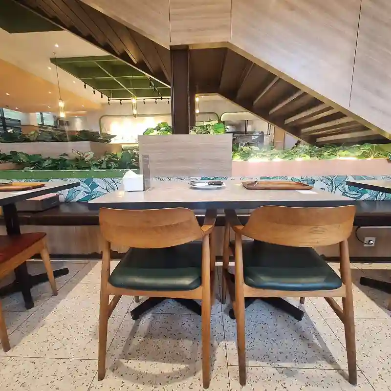 Sillas de madera para restaurante en Quintana Roo — modelo moderno con asiento tapizado en cuero verde, ideales para espacios gastronómicos con diseño biofílico en Cancún y Playa del Carmen